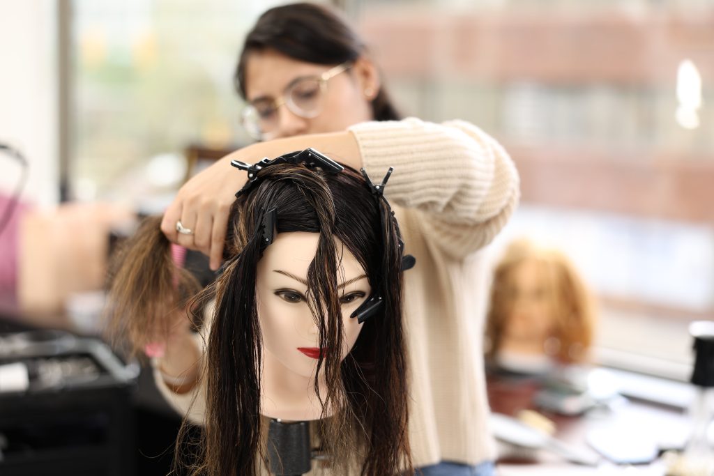 Student learning hair styling at Orane International College in Canada